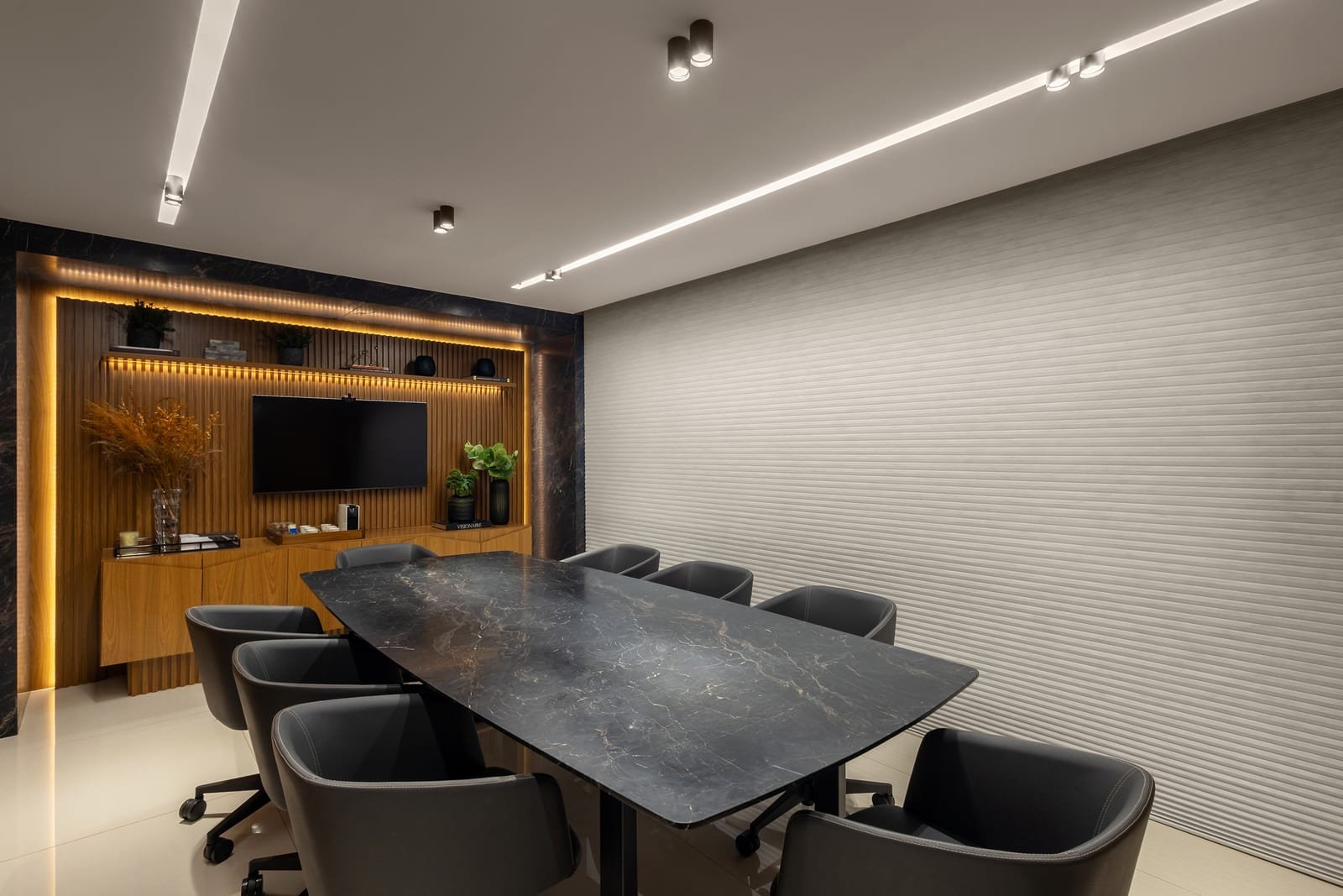 Sala de reunião do escritório, com mesa para oito lugares