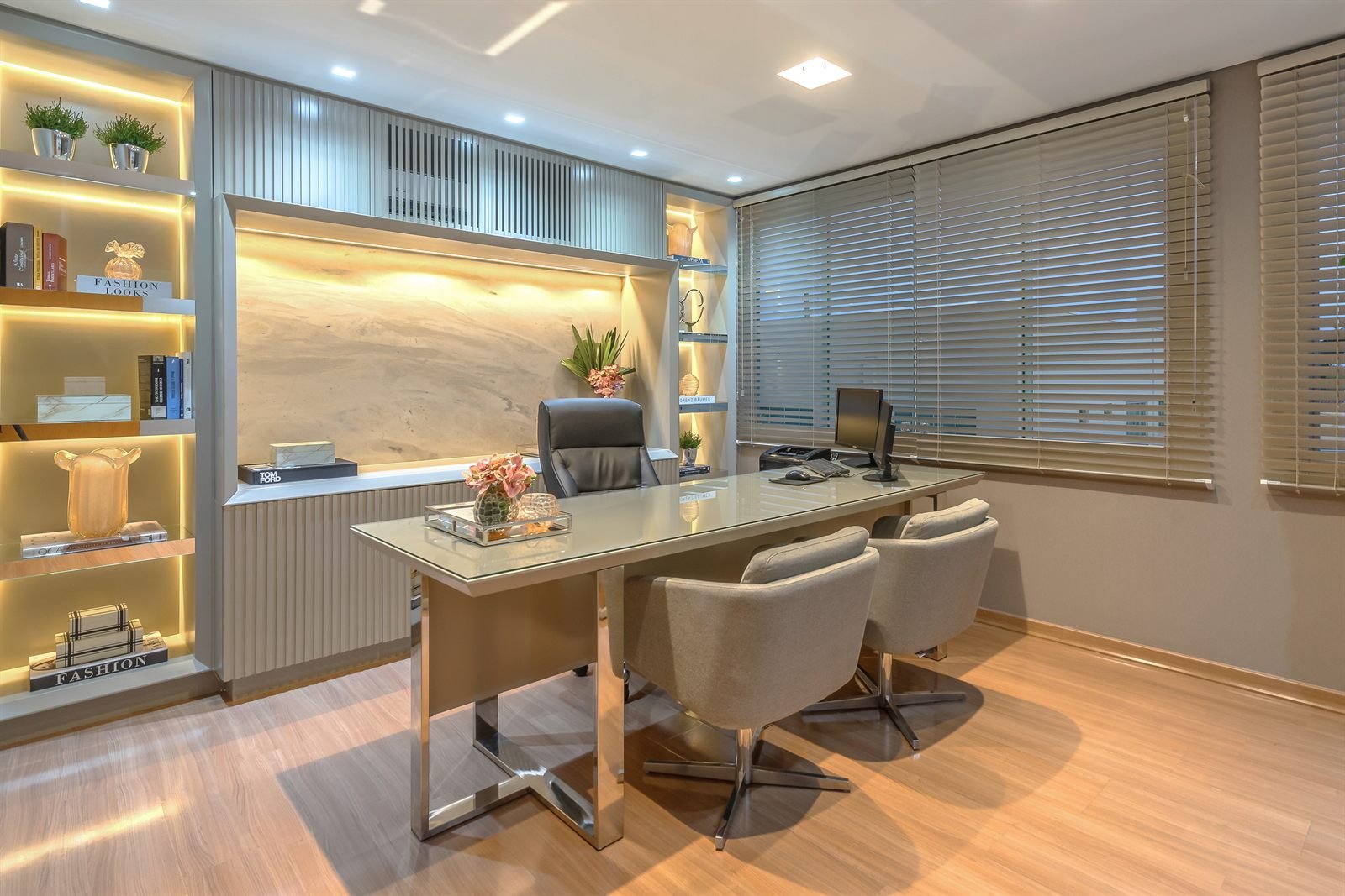 Sala de atendimento com estante iluminada e mesa de vidro